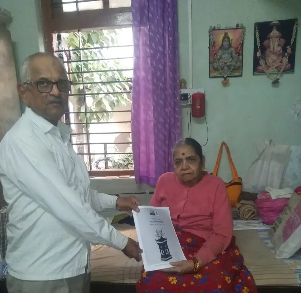 Dr. Vasudha Joshi being given a printed copy of Chitpavni Anka "Saad Chitpavanicho" by Shri Vilas Joshi in Pune